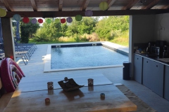 Blick aus dem Poolhaus auf Pool und Garten